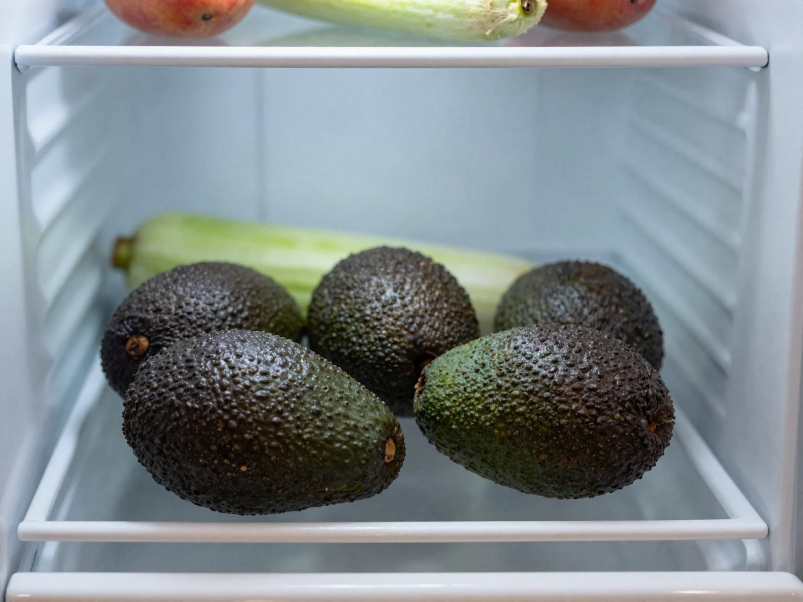 How to store avocados: whole ripe avocados lying loose on a refrigerator shelf