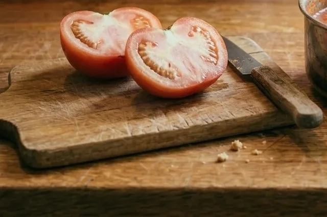 A supermarket tomato cut in half, the flesh pale and grainy near the core.