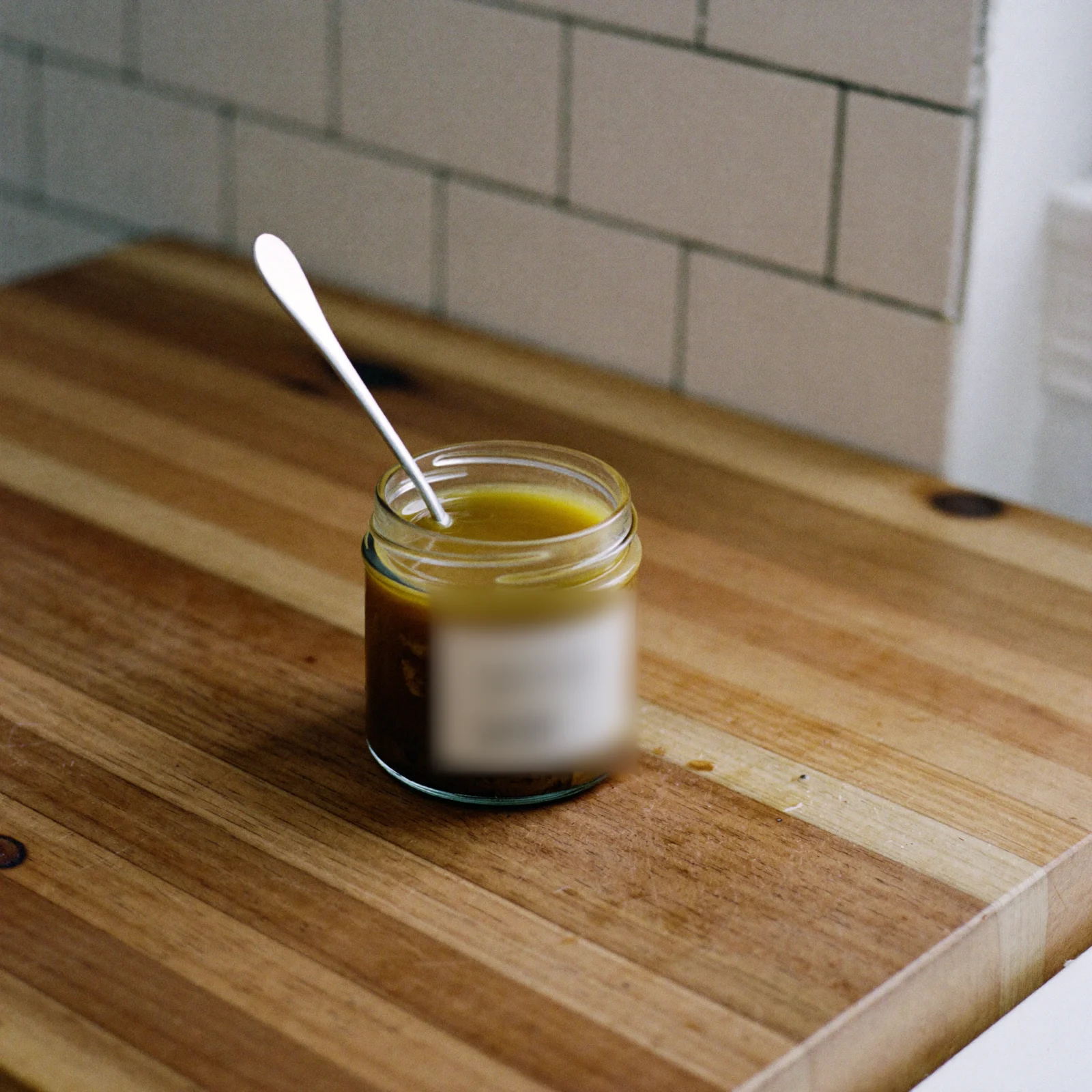 An open jar of almond butter with a layer of golden oil on top of darker paste