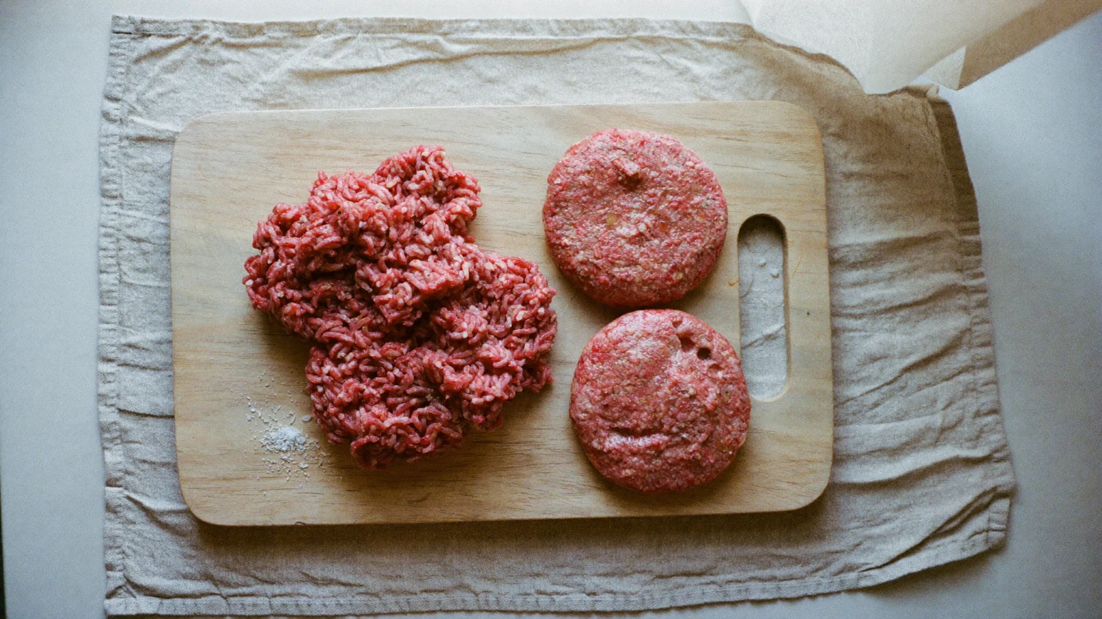 How to Store Ground Beef -Fresh bright red ground beef in a loose mound on a beech-wood board