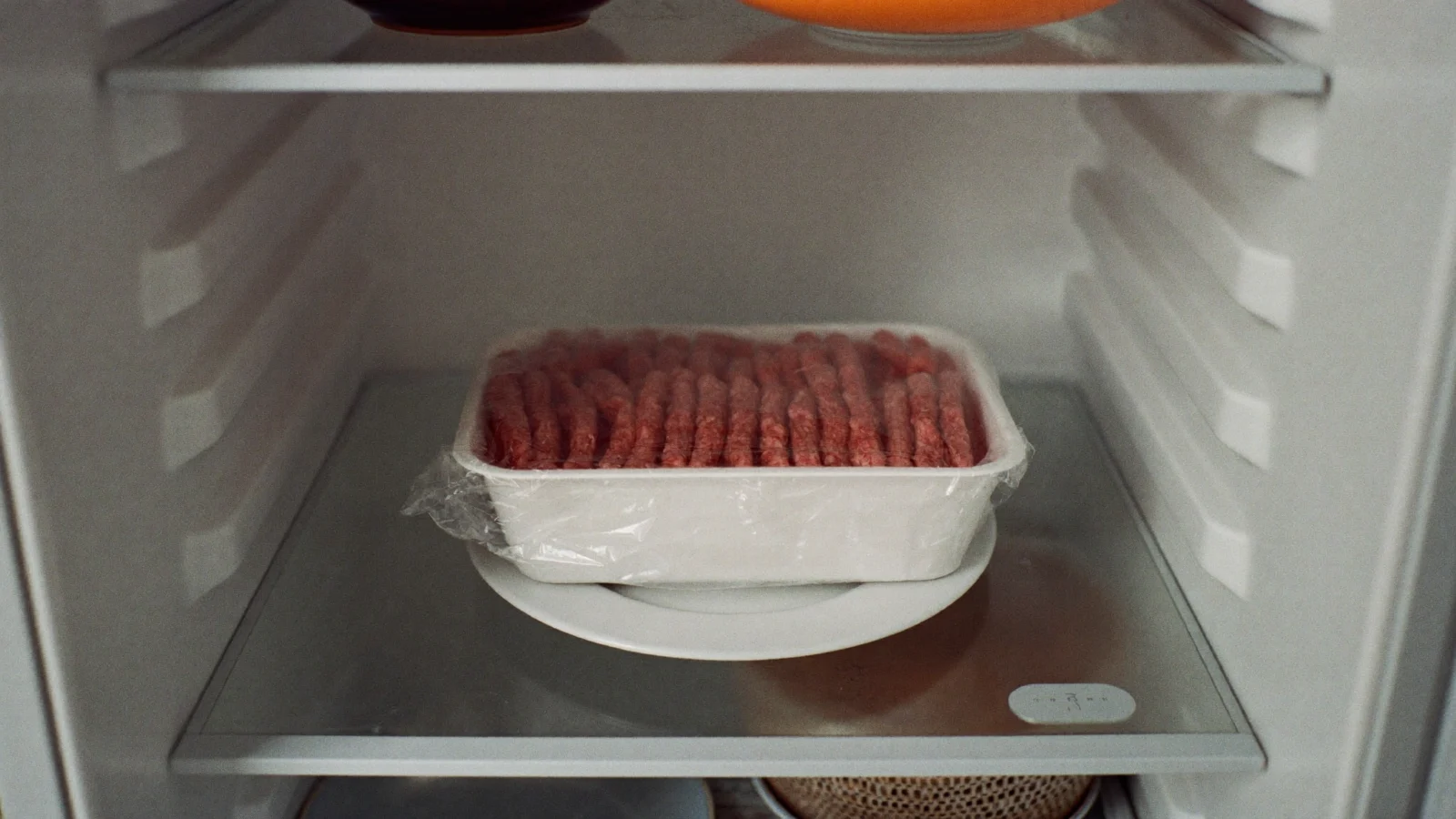 Store ground beef in its package on a plate in the fridge