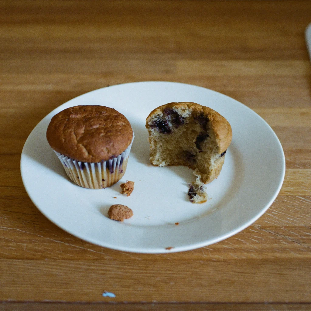 An old blueberry muffin with a dull top and a dry, crumbly inside