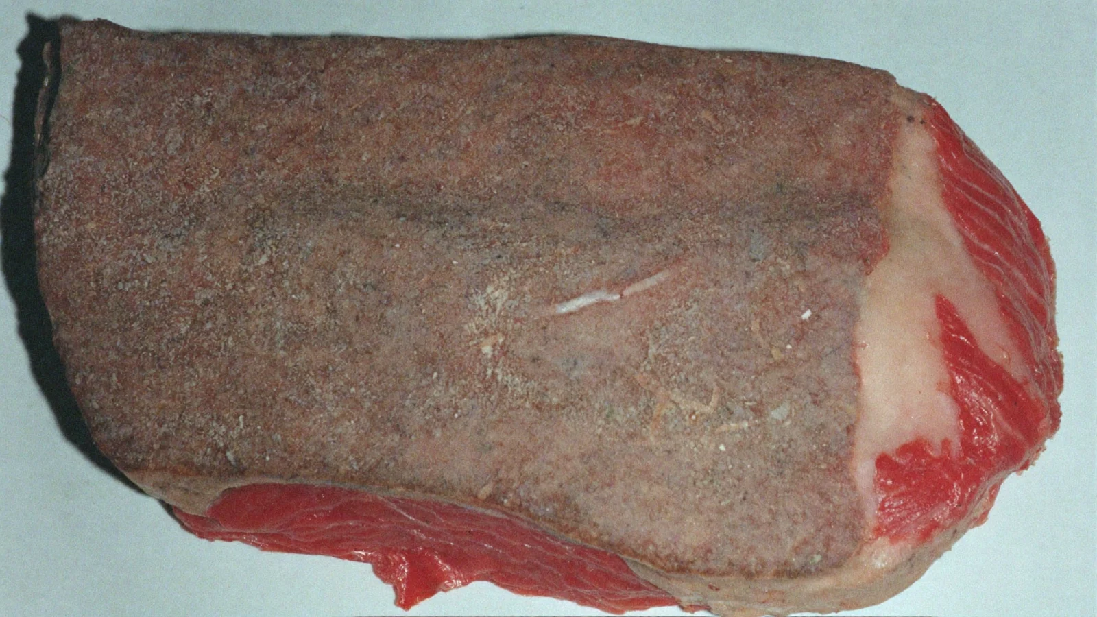 A raw steak whose surface has turned brownish-grey, with red showing at the cut edge