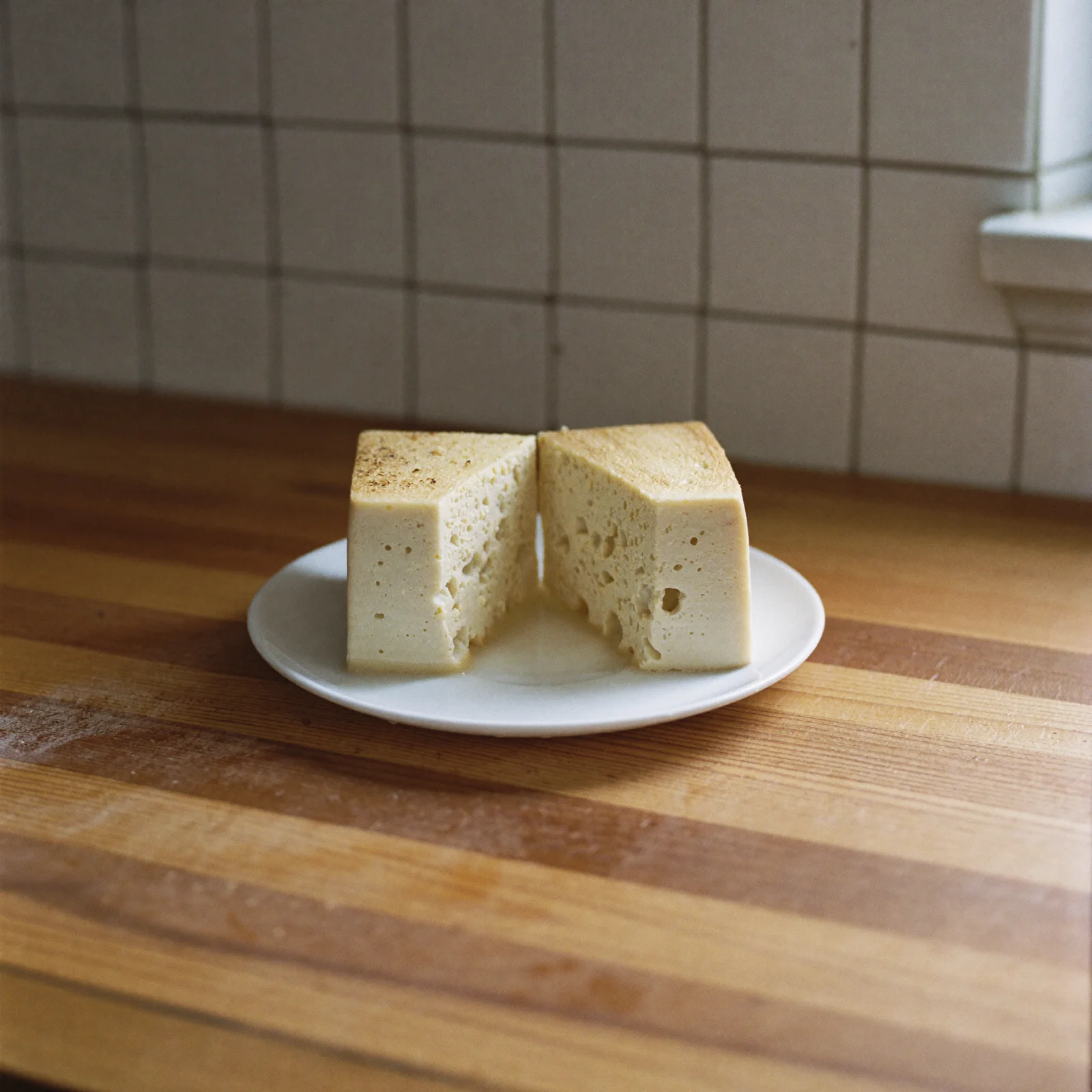 Thawed tofu cut open to show the open, spongy texture that freezing leaves