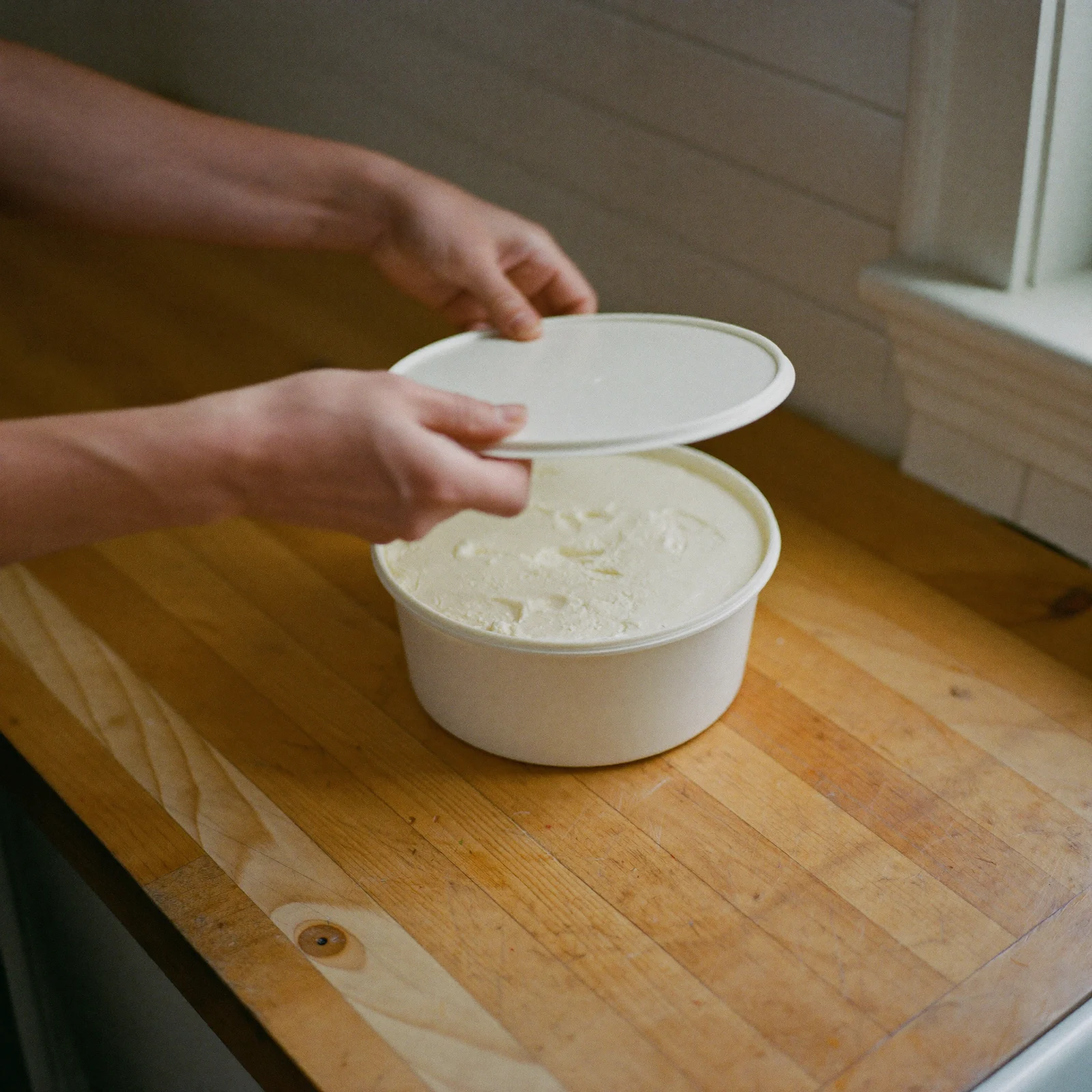Pressing the lid onto a tub of vegetable shortening before storing it