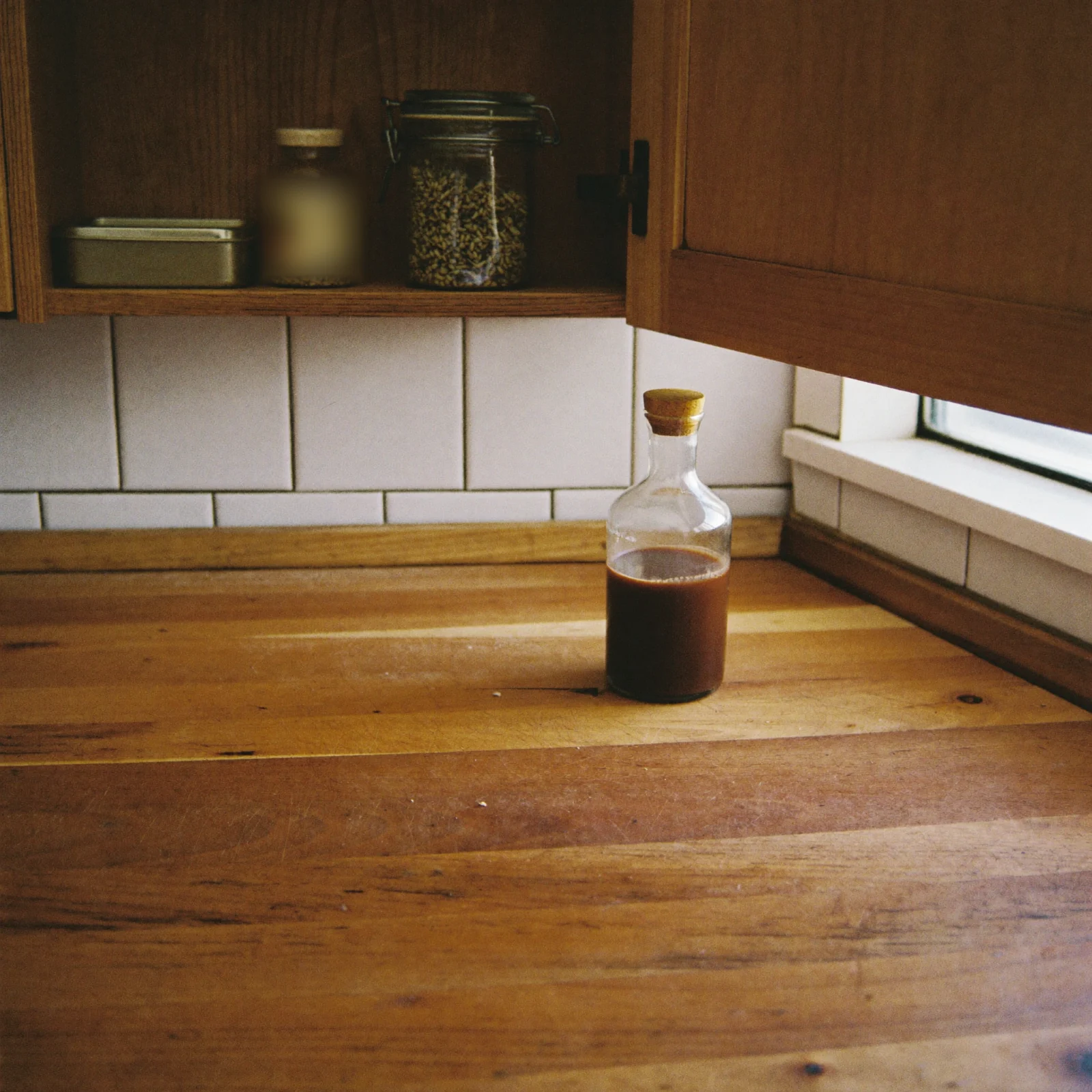 How to store Worcestershire sauce: a corked bottle in a cool, shaded kitchen corner below the cupboard